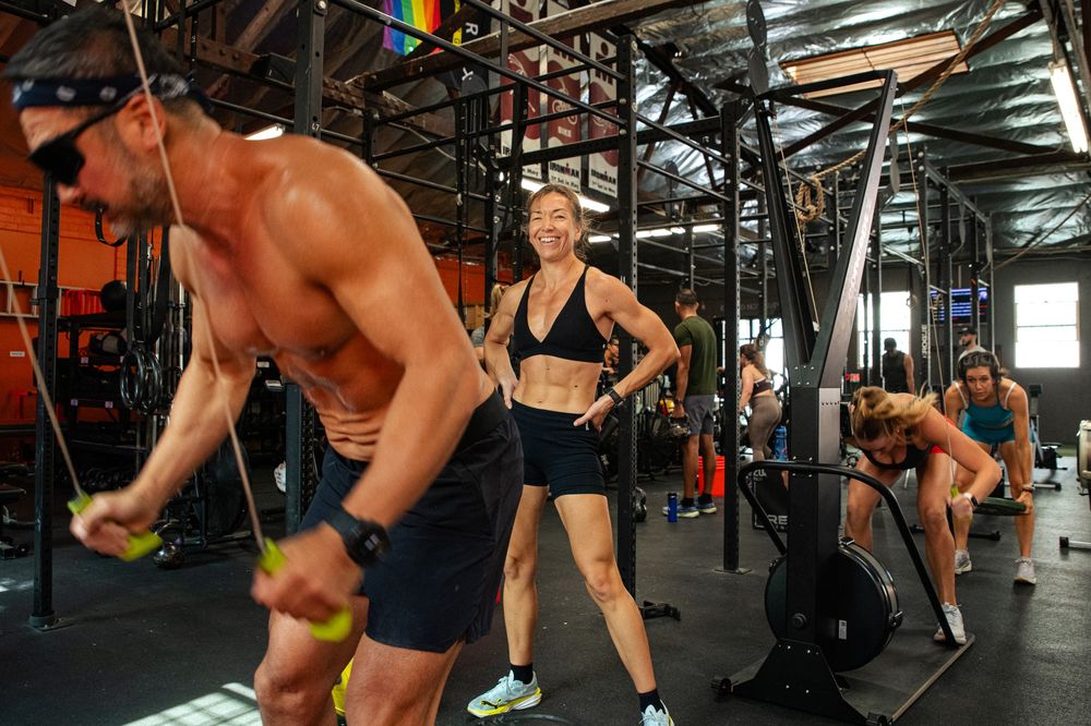 Athletes on the SkiErg and rower during class