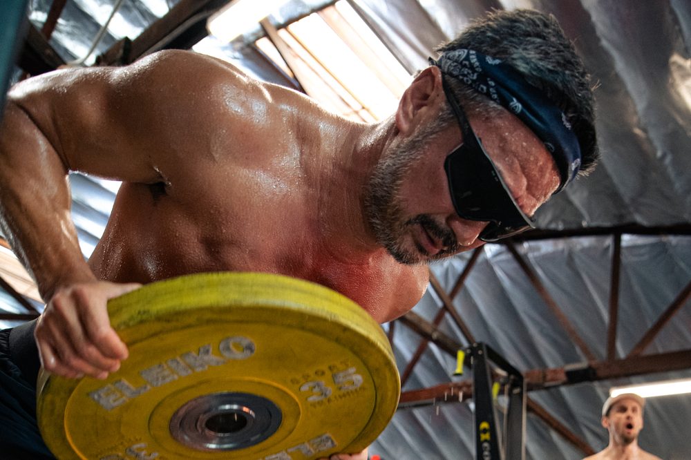 An athlete working with a bumper plate during Ganbatte Engine